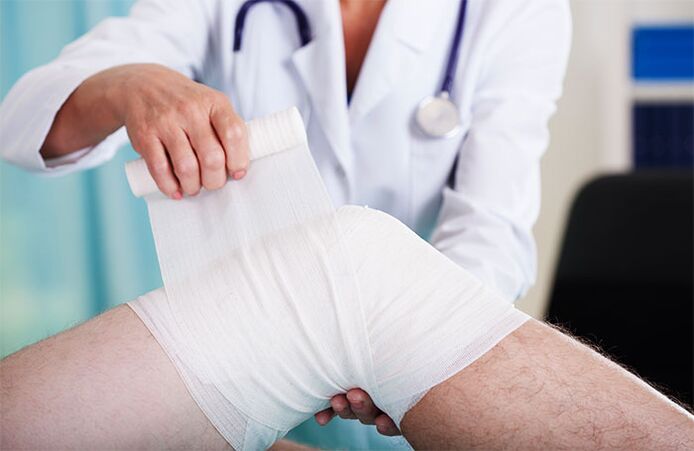 zdravnik, ki previja kolenski sklep z artrozo